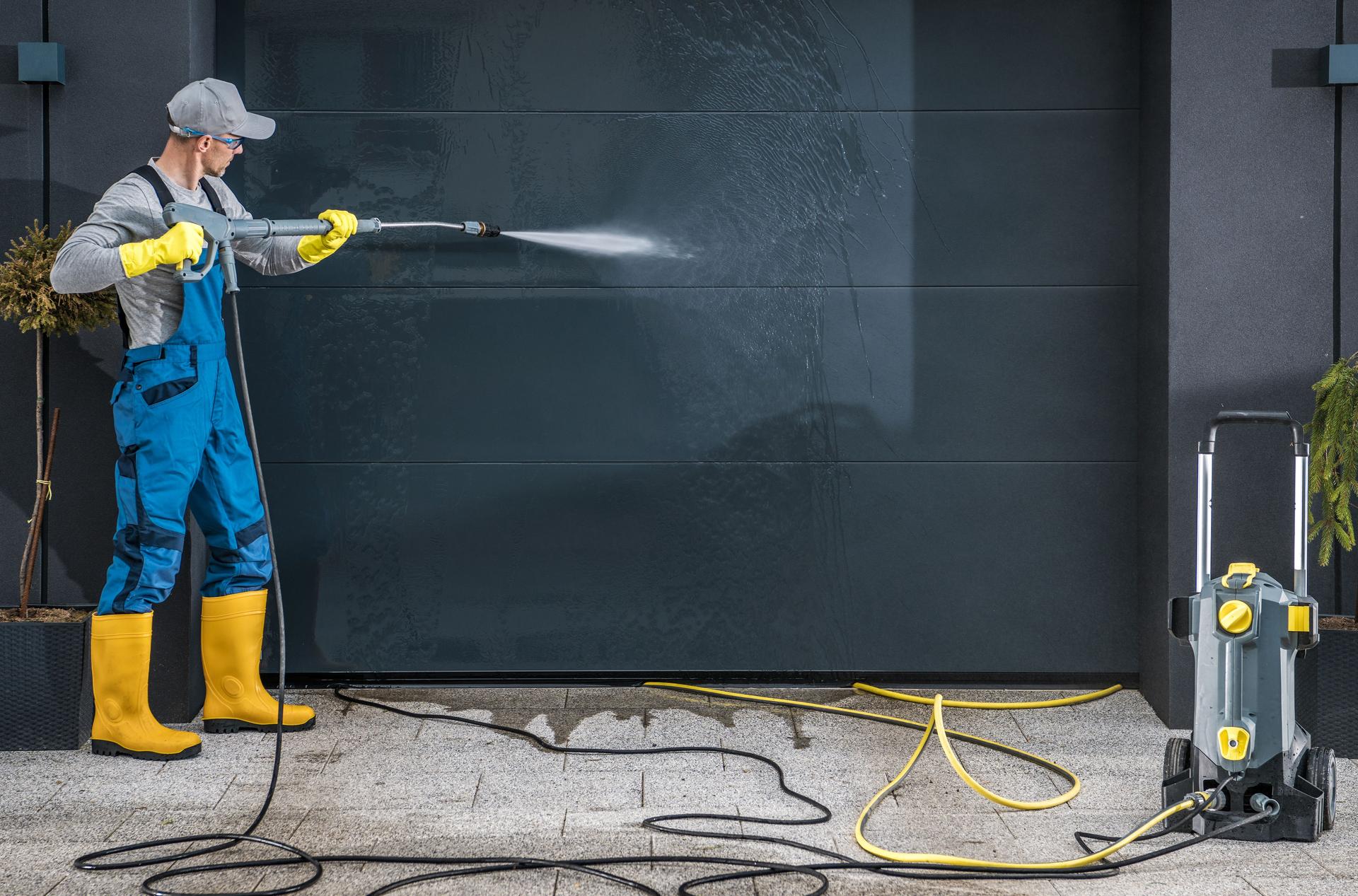 Mature Man Cleaning Garage Shutter Outdoors